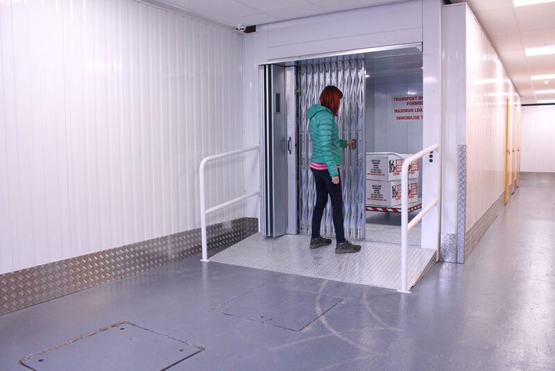 woman wearing green jacket doing self storage