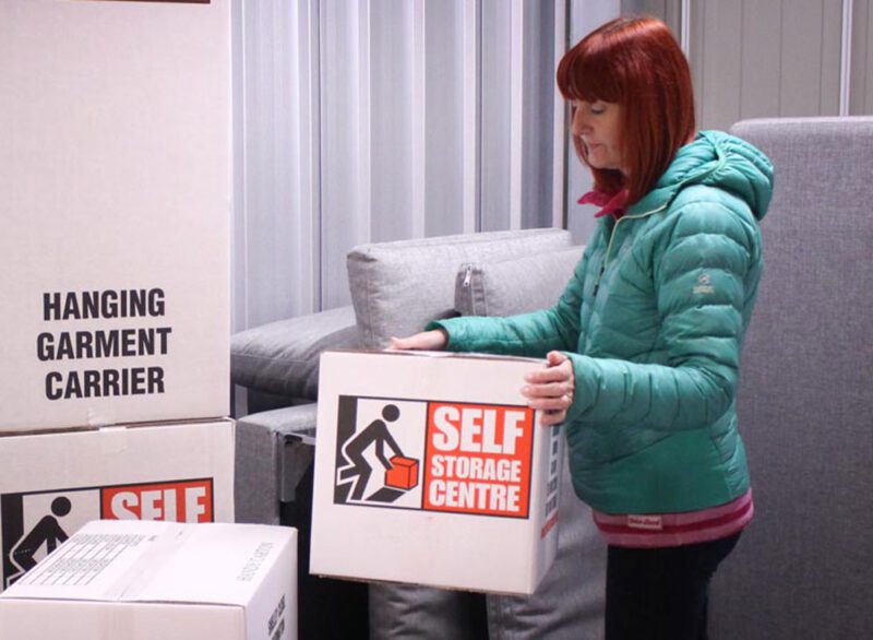woman wearing green jacket holding box storage